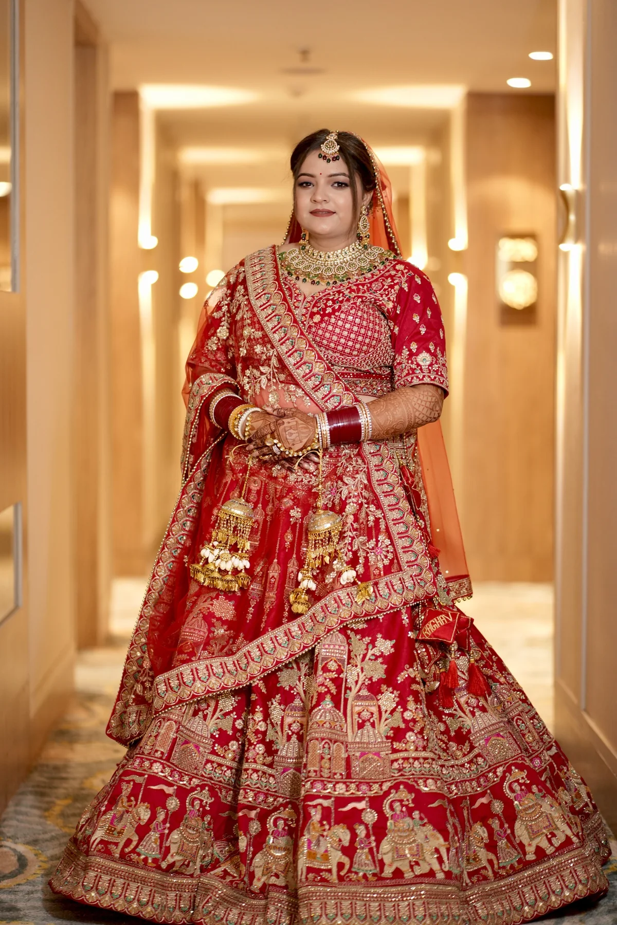 Full-length bridal portrait in red wedding lehenga