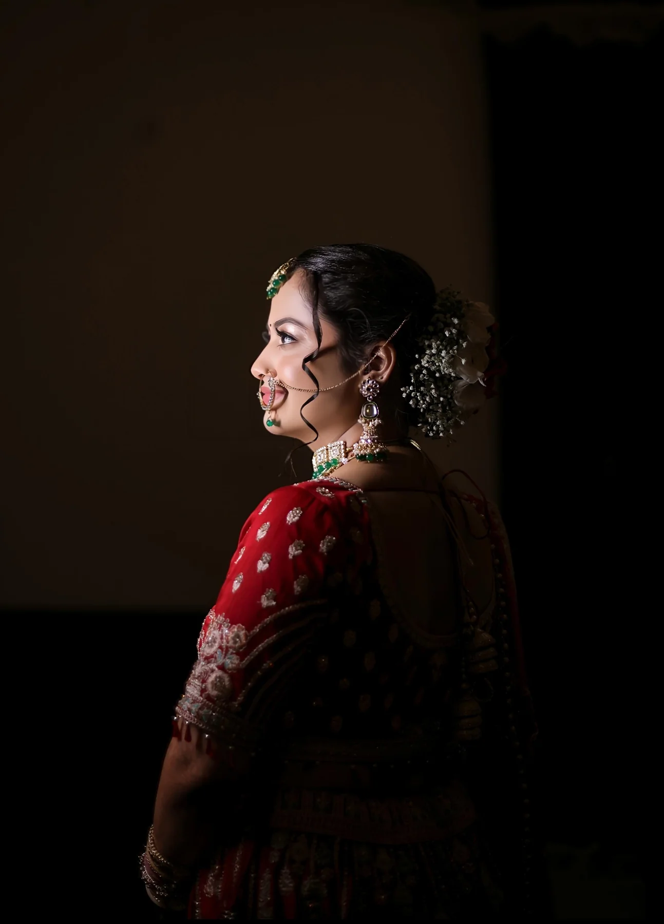 Dramatic bridal portrait with soft shadow and red lehenga