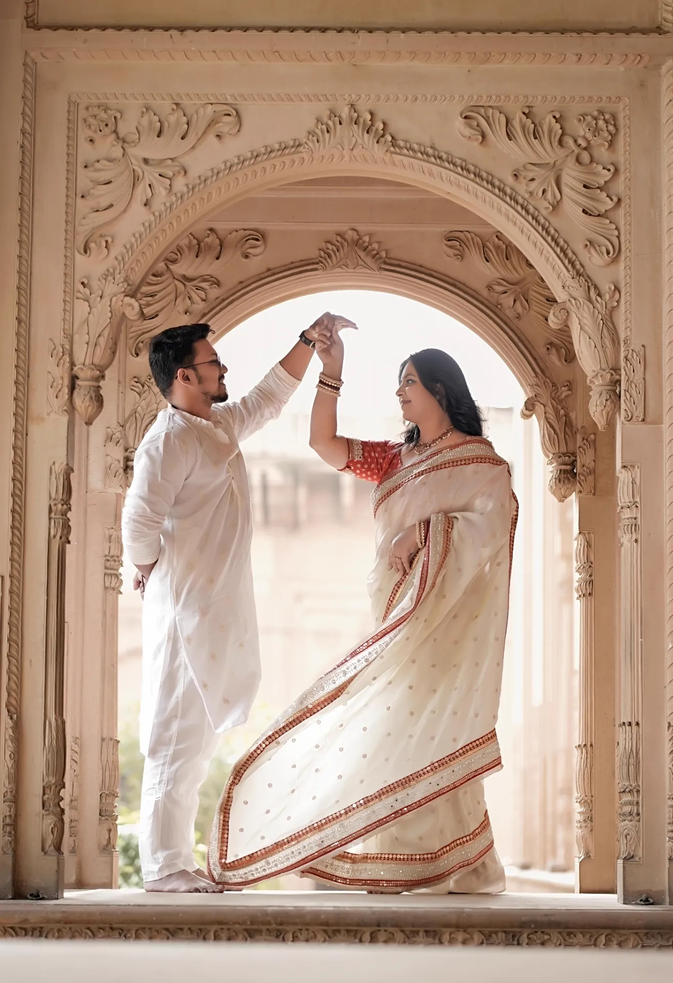 Backlit dance pose framed by an ornate sandstone arch