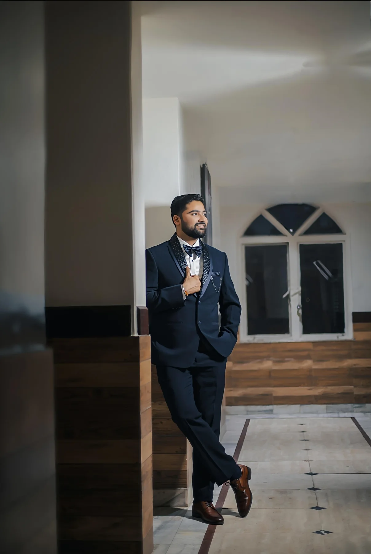 Groom in a black suit with cinematic shadows