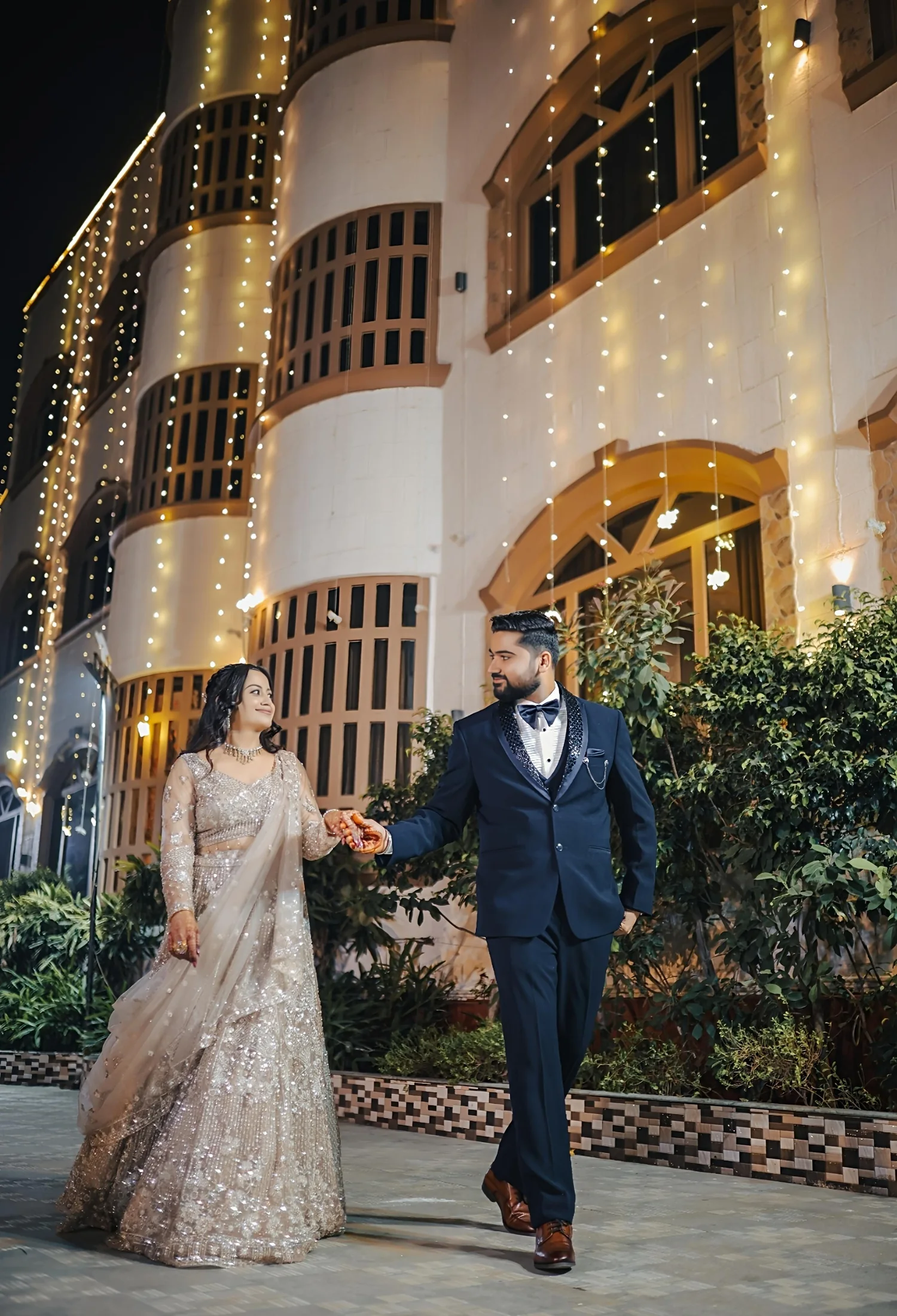 Couple walking together under warm fairy lights